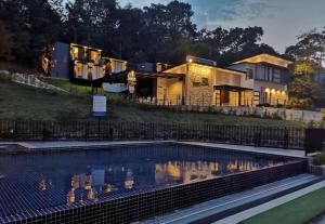 a house with a swimming pool in front of a house at Lilla Waterfall Retreat - Sg Lembing, Kuantan Formerly Known as Casa Hill Resort in Sungai Lembing