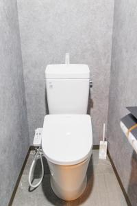 ein Badezimmer mit einer weißen Toilette in einer Kabine in der Unterkunft HOTEL STAY Plus in Imabari