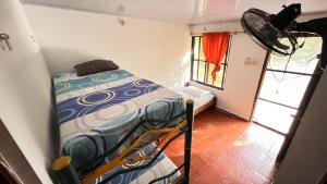 a small bedroom with a bed and a window at Eden Garden in Santa Marta
