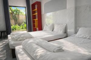 two beds in a room with a window at Newlife Homestay & Restaurant in Dong Hoi