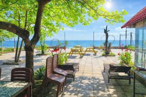 a patio with chairs and tables and the ocean at Newlife Homestay & Restaurant in Dong Hoi +58 photos