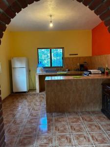 a kitchen with a white refrigerator in a room at Casa El Limón in Yelapa