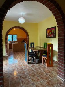 a living room with a table and chairs and a kitchen at Casa El Limón in Yelapa