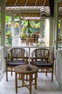 a porch with two chairs and a table on a porch at The Lucky Cottage in Nusa Lembongan