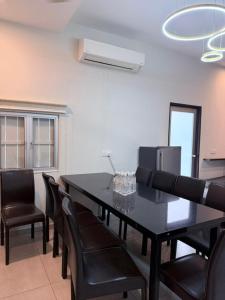 a dining room with a black table and chairs at Lilla Waterfall Retreat - Sg Lembing, Kuantan Formerly Known as Casa Hill Resort in Sungai Lembing +86 photos