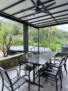 a table and chairs on a patio with a ceiling fan at Lilla Waterfall Retreat - Sg Lembing, Kuantan Formerly Known as Casa Hill Resort in Sungai Lembing