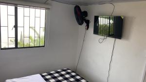 a room with a bed and a television on a wall at Habitaciones cama doble in La Vega