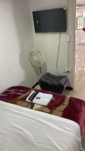 a bedroom with a bed with a television and a fan at Habitaciones cama doble in La Vega +2 photos