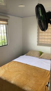 a bedroom with a bed with a fan above it at Habitaciones cama doble in La Vega