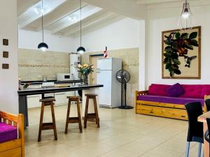 a kitchen and living room with a purple couch at LA ESQUINA DE LA FLOR in Campo Quijano