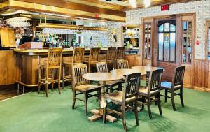 a restaurant with wooden tables and chairs and a bar at Riverview Lodge in Dryden