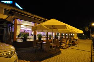 un restaurante con mesas y sillas bajo una sombrilla amarilla en Pass Hotel, en Zebrzydowice