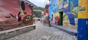 a street with paintings on the sides of buildings at Hotel San Marcos Las Lajas in Ipiales