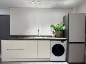 a kitchen with a sink and a washing machine at DADA Stay Hongdae in Seoul +20 photos