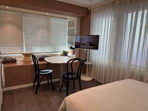 a hotel room with a table and chairs and a television at DADA Stay Hongdae in Seoul