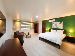 a bedroom with a bed and a green wall at The Nest Bed and Breakfast - Kalibo in Kalibo