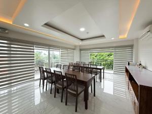 a dining room with tables and chairs and windows at The Nest Bed and Breakfast - Kalibo in Kalibo