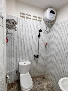 a small bathroom with a toilet and a sink at G-House-2 in Singkawang +10 photos