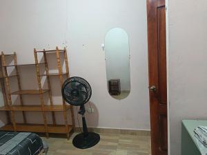 a room with a fan and a mirror on the wall at Departamento amoblado in Nueva Loja