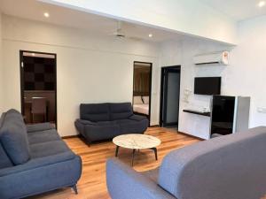 a living room with two blue couches and a table at Lilla Waterfall Retreat - Sg Lembing, Kuantan Formerly Known as Casa Hill Resort in Sungai Lembing
