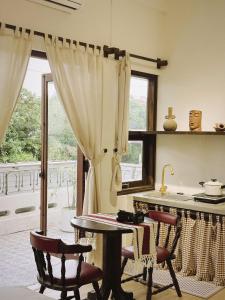 a kitchen with a table and chairs and a window at Jin homestay in Thôn Lại Thê