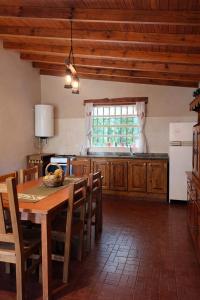 a kitchen with a wooden table and a window at El Bosque de Simba - Cabaña in La Estancia +10 photos