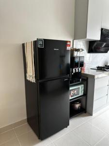 a black refrigerator in a kitchen next to a counter at NHI Home Paka in Paka