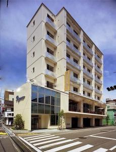 un edificio blanco alto en la esquina de una calle en Kochi Ryoma Hotel, en Kochi