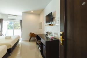 a hotel room with a bed and a desk in it at บ้านสวนสมบูรณ์ in Sangkhla Buri