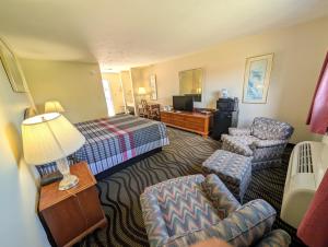 a hotel room with a bed and a living room at The Falls Motel - 2 Mi to " Watkins Glen State Park, Wineries " and 4 Mi to Watkins Glen International Track " The Glen " in Watkins Glen