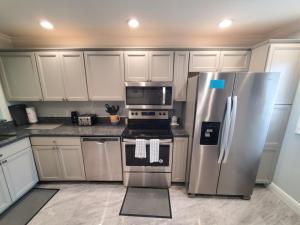 a kitchen with white cabinets and a stove and refrigerator at Summerhouse 218 condo in St. Augustine