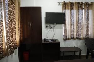 a room with a television and a desk with a chair at Shree mahal in Jāmb