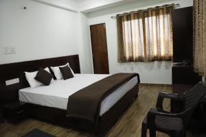 a bedroom with a large bed and a chair at Shree mahal in Jāmb