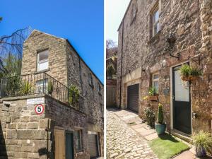 an old brick building with a door and a balcony at Kirkham House in Matlock