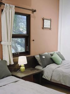 a living room with two beds and a window at Jin homestay in Thôn Lại Thê