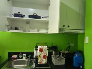 a kitchen counter with a sink and green walls at 1BR Condo w Pool & Balcony Near Robinson Place - F&M Homes - Sitio Uno Residences, Pueblo de Panay in Roxas City