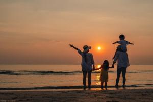 a family standing on the beach watching the sunset at Odysis Onna Resort Hotel in Onna