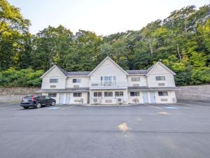 a large white house with a car parked in a parking lot at The Falls Motel - 2 Mi to " Watkins Glen State Park, Wineries " and 4 Mi to Watkins Glen International Track " The Glen " in Watkins Glen
