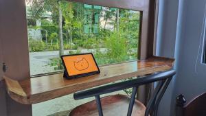 a laptop computer sitting on a desk next to a window at Casa Munti Garden Lodge in Daet