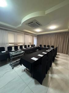 a conference room with black tables and black chairs at Carina Hotel in Tczew