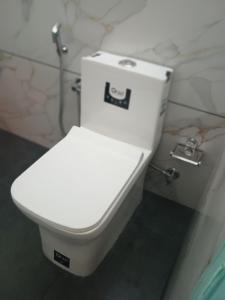 a white toilet in a bathroom with marble walls at IDANN Homestay in Cochin +46 photos