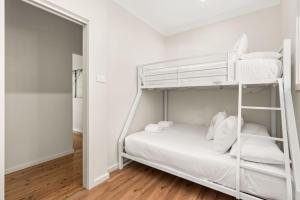 a white bunk bed in a white room at Husky Days in Huskisson