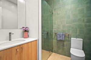 a bathroom with a toilet and a sink and a shower at Harborview Modern Apartment 8F in Victor Harbor +20 photos