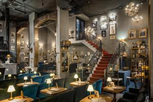 a restaurant with tables and chairs and a staircase at Montraj Coach Sukhumvit Bangkok in Bangkok