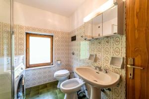 a bathroom with a toilet and a sink at Casa Mirabella in Sottoguda +4 photos