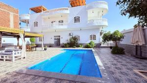 a house with a swimming pool in front of it at Panorama Hotel in Luxor