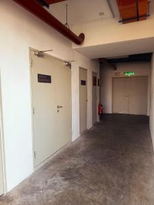 an empty room with two garage doors in a building at IFS Soho 3 Basic Home in Seri Iskandar