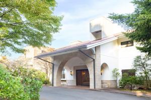 a white building with an archway next to a street at TAOYA Hakone in Hakone