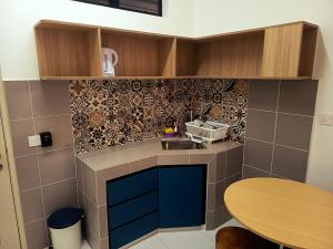a small kitchen with blue cabinets and a table at IFS Soho 3 Basic Home in Seri Iskandar