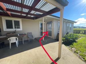 a patio with awning and a table and chairs at Self check-in double or single rooms in guests house in Te Miro